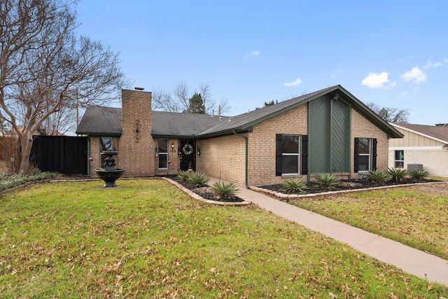 mid-century home with brick siding, a chimney, a front lawn, and fence