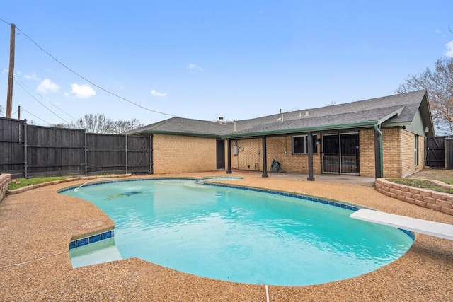 view of pool featuring a diving board, a patio area, a fenced backyard, and a fenced in pool