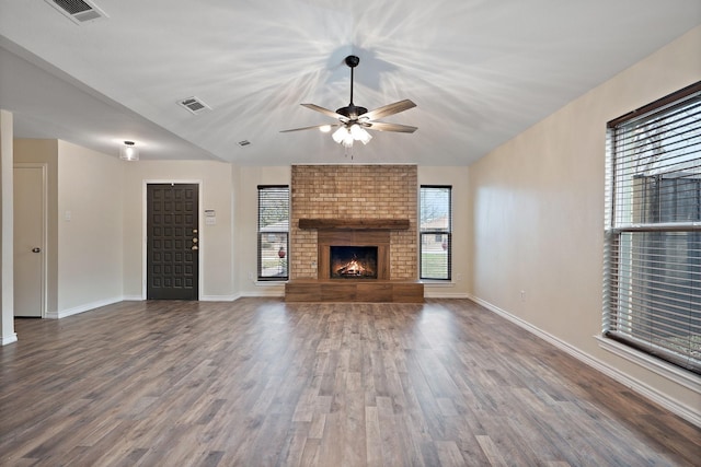 unfurnished living room featuring wood finished floors, visible vents, and a healthy amount of sunlight