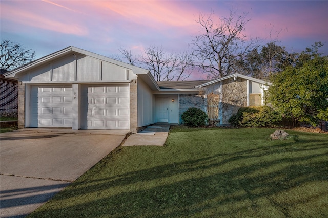 view of front of home with a garage, driveway, stone siding, a yard, and brick siding