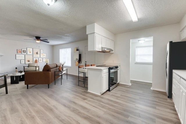 kitchen featuring appliances with stainless steel finishes, white cabinets, and light countertops