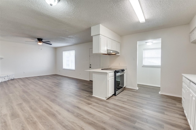 kitchen with light wood-style flooring, white cabinetry, light countertops, and stainless steel range with electric cooktop