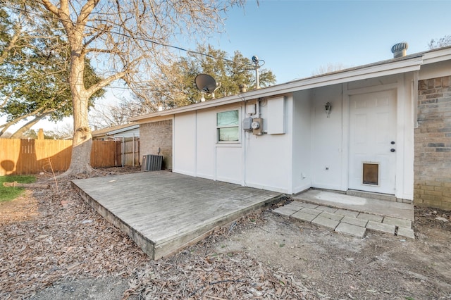 back of house featuring central air condition unit, fence, and brick siding