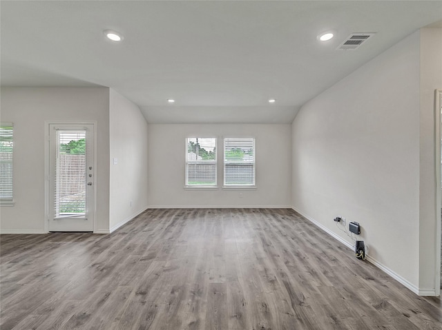 unfurnished room featuring plenty of natural light, wood finished floors, and visible vents