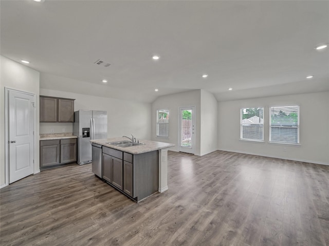 kitchen with visible vents, appliances with stainless steel finishes, open floor plan, wood finished floors, and a sink