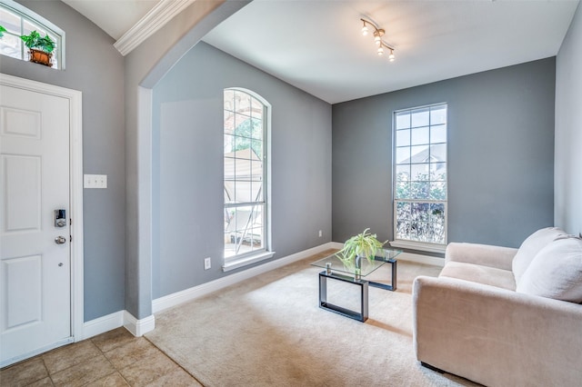 interior space with arched walkways, baseboards, tile patterned flooring, and a healthy amount of sunlight