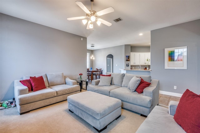 living area with arched walkways, visible vents, ceiling fan, and baseboards