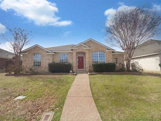 ranch-style house with a front yard and brick siding