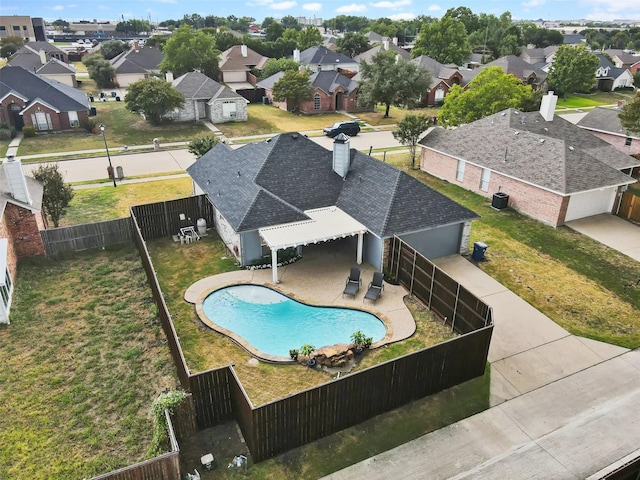 view of swimming pool with a yard, a fenced backyard, a residential view, and a patio