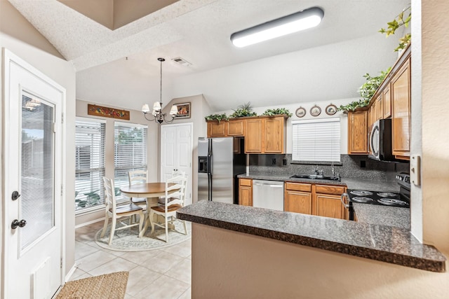 kitchen featuring lofted ceiling, a notable chandelier, a peninsula, visible vents, and appliances with stainless steel finishes