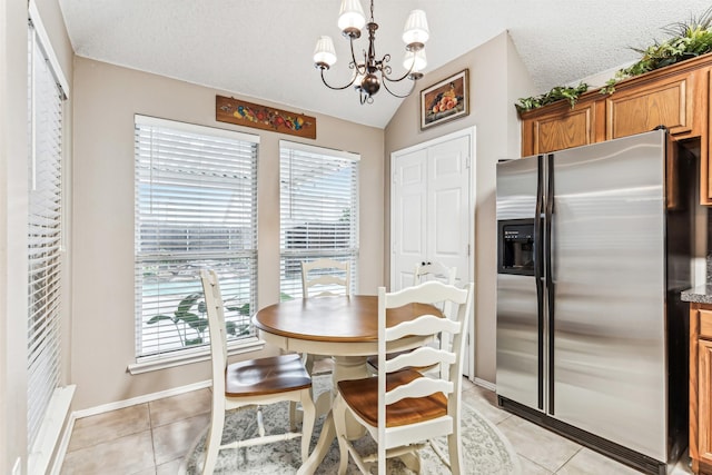 dining room with light tile patterned floors, an inviting chandelier, lofted ceiling, and a healthy amount of sunlight