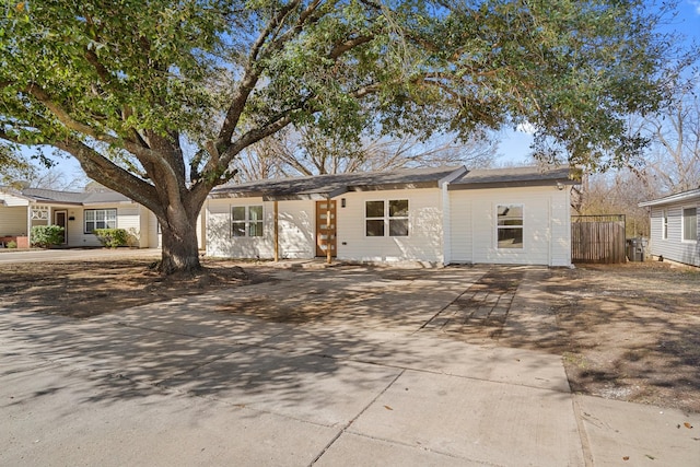 ranch-style house with driveway and fence