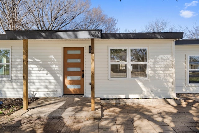 view of exterior entry featuring a patio area