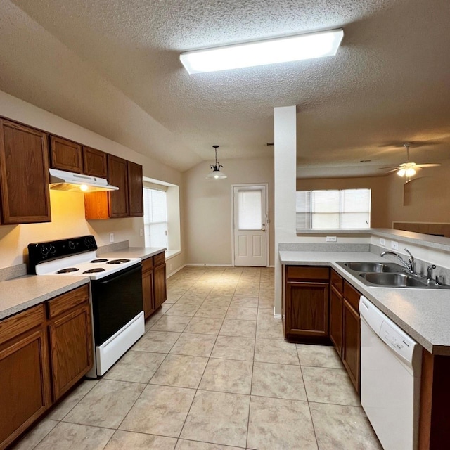 kitchen featuring light tile patterned floors, under cabinet range hood, white appliances, a sink, and light countertops