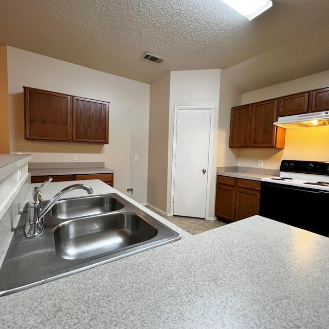 kitchen featuring visible vents, electric range oven, a sink, a textured ceiling, and under cabinet range hood