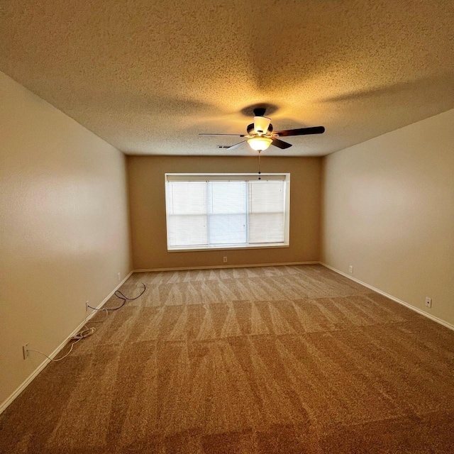 spare room featuring a textured ceiling, baseboards, a ceiling fan, and light colored carpet