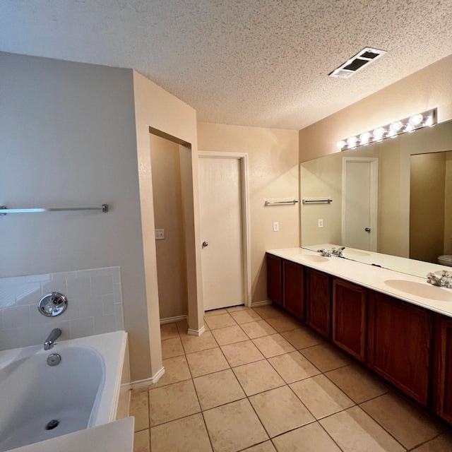 full bathroom with a garden tub, a sink, visible vents, tile patterned floors, and double vanity