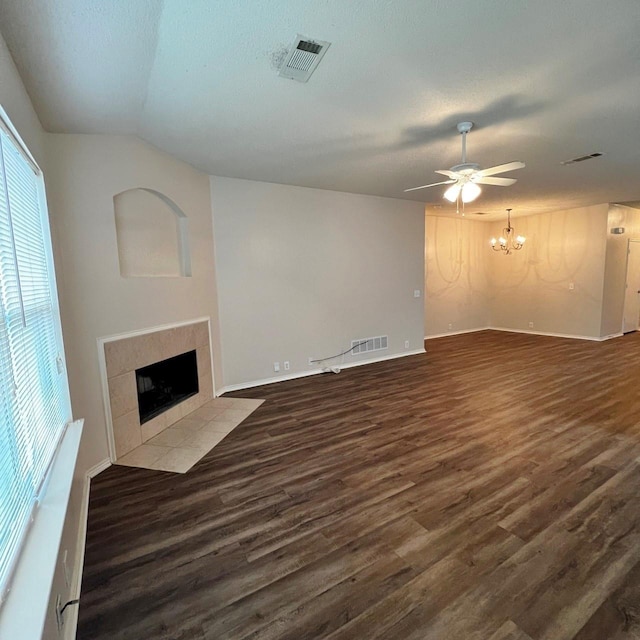 unfurnished living room featuring wood finished floors, a tile fireplace, and visible vents