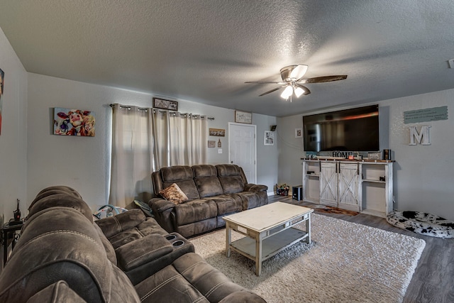 living area featuring ceiling fan, a textured ceiling, wood finished floors, and visible vents