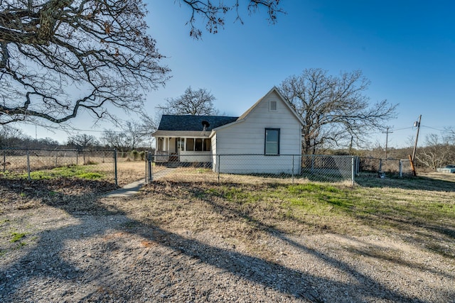 rear view of property with a fenced front yard and a gate