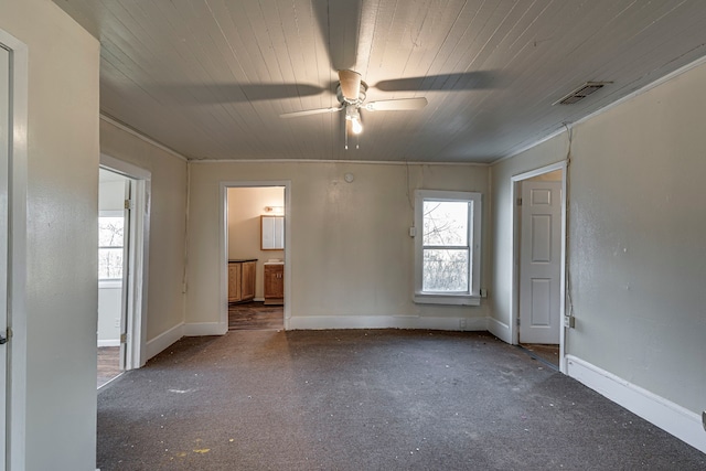 spare room featuring wooden ceiling, baseboards, visible vents, and a ceiling fan