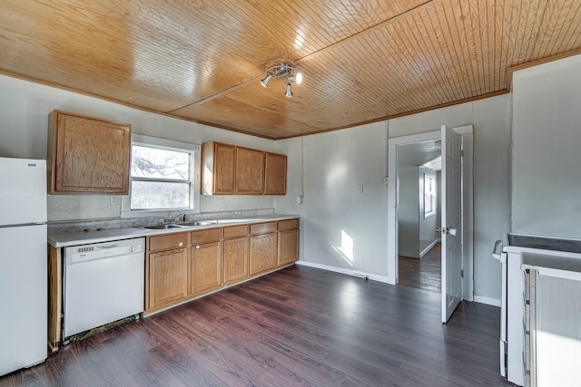 kitchen with dark wood finished floors, white appliances, light countertops, and a sink