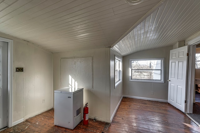 interior space featuring lofted ceiling, wooden ceiling, baseboards, and hardwood / wood-style floors