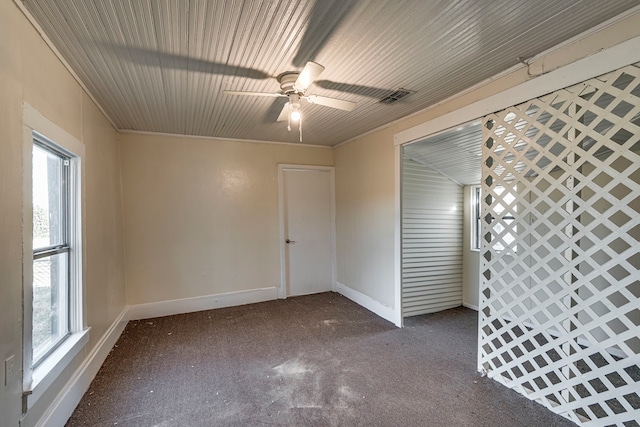 empty room with visible vents, ceiling fan, and baseboards