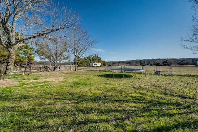 view of yard featuring a fenced backyard, a trampoline, and a rural view