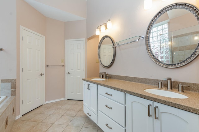 bathroom with double vanity, tiled bath, a sink, tile patterned flooring, and tiled shower