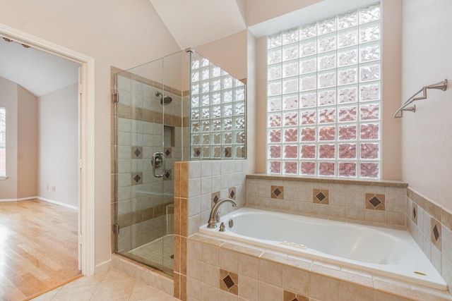 full bath with a stall shower, tile patterned flooring, and a bath