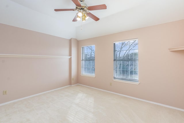 spare room with light carpet, baseboards, a ceiling fan, and lofted ceiling