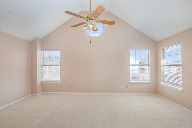 empty room with plenty of natural light, a ceiling fan, and light colored carpet