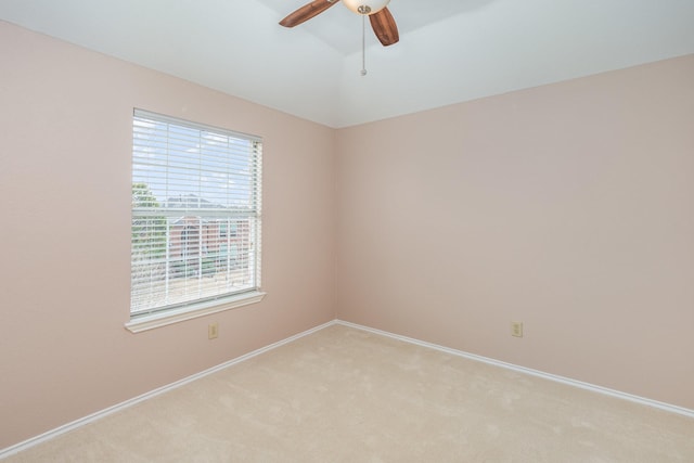 unfurnished room with a ceiling fan, lofted ceiling, light carpet, and baseboards