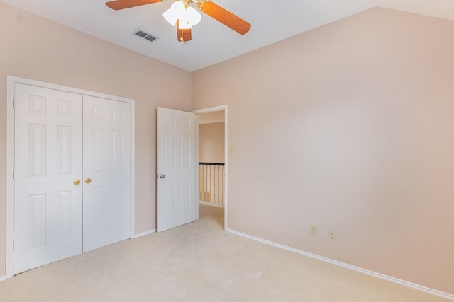 unfurnished bedroom featuring a closet, visible vents, light carpet, and baseboards