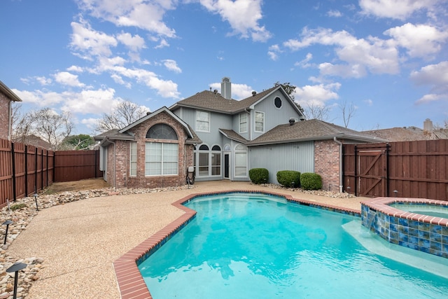 view of swimming pool featuring a gate, a patio area, a pool with connected hot tub, and a fenced backyard