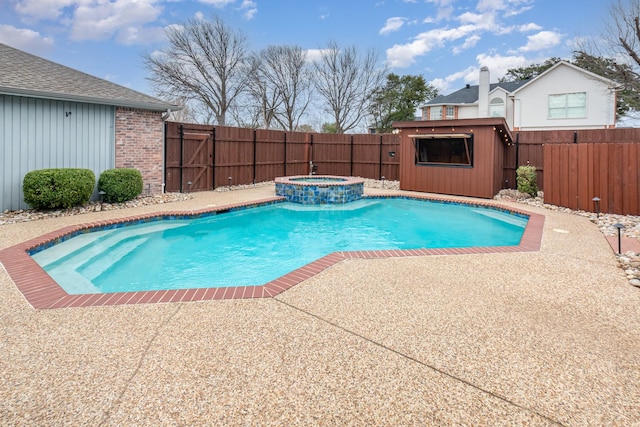 view of swimming pool featuring an outbuilding, a fenced backyard, a pool with connected hot tub, a shed, and a patio area