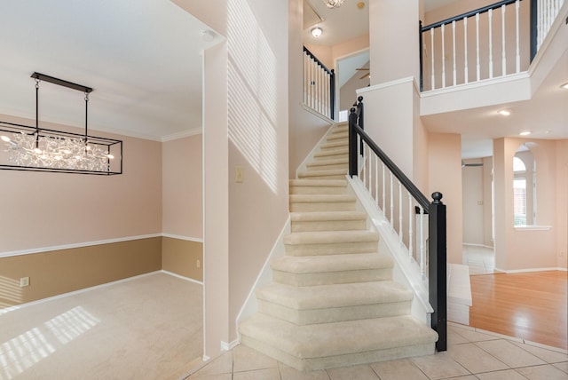 stairway with tile patterned flooring, crown molding, arched walkways, and baseboards