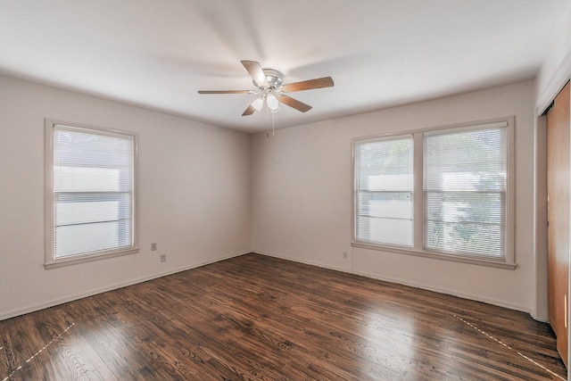 spare room with dark wood-style floors, ceiling fan, and baseboards