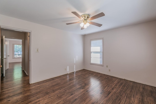 spare room with dark wood-style floors, ceiling fan, and baseboards