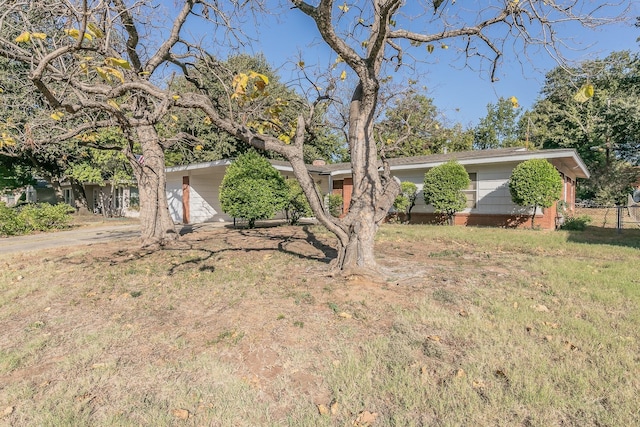 view of front of home featuring driveway, a front lawn, and fence