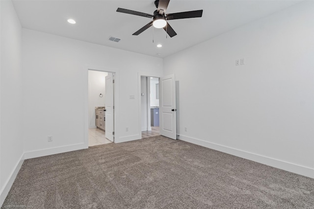 unfurnished bedroom featuring light carpet, baseboards, visible vents, and ensuite bathroom