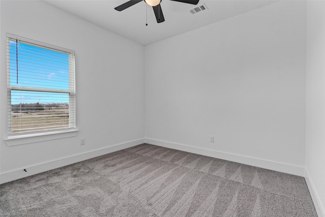 carpeted empty room featuring a ceiling fan, visible vents, and baseboards