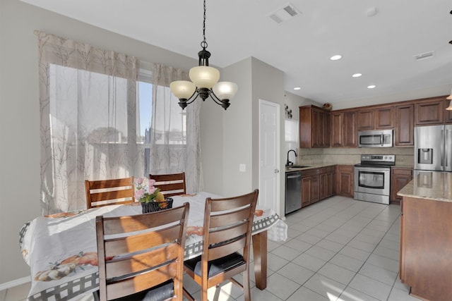 kitchen featuring light tile patterned flooring, visible vents, appliances with stainless steel finishes, decorative backsplash, and pendant lighting