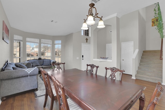 dining room featuring dark wood-type flooring, visible vents, and stairs