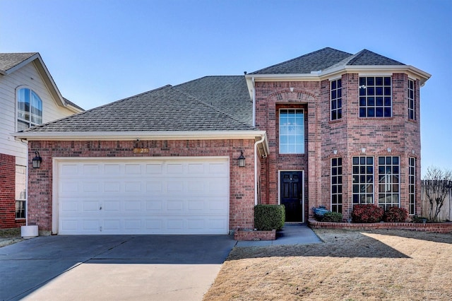 traditional-style home featuring driveway, roof with shingles, a garage, and brick siding