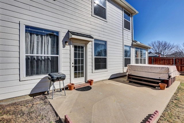 view of patio featuring a hot tub, fence, and grilling area