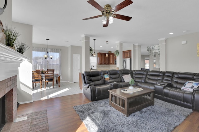 living area with plenty of natural light, a brick fireplace, and light wood-style flooring