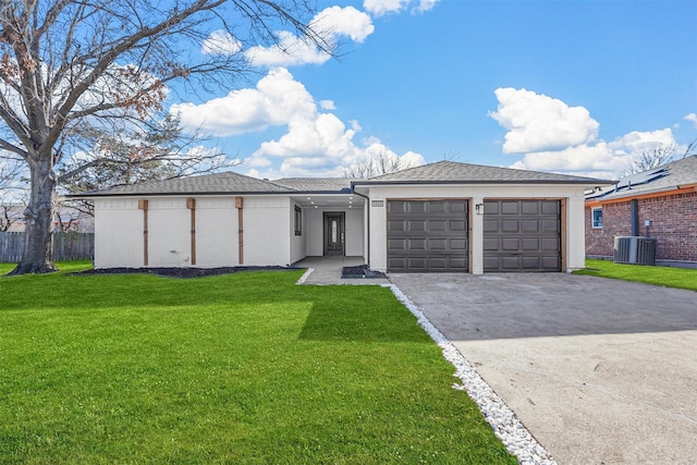 view of front facade with concrete driveway, an attached garage, central AC, fence, and a front lawn