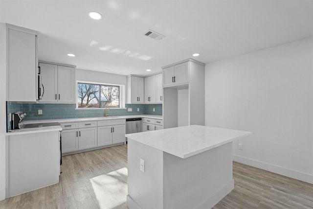 kitchen with visible vents, light wood-style floors, light countertops, appliances with stainless steel finishes, and tasteful backsplash